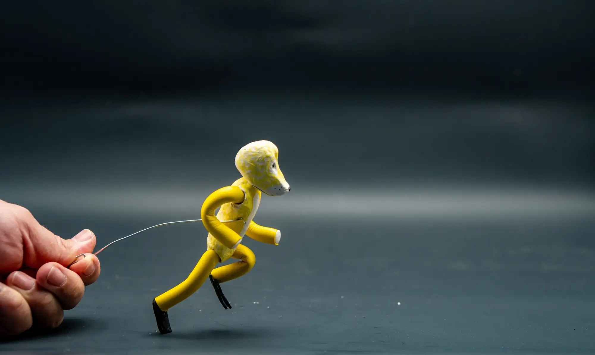 Shutterstock_2229772873 | TVGURU.cz osoba drží postavičku na drátku v rámci tvorby stop-motion animace