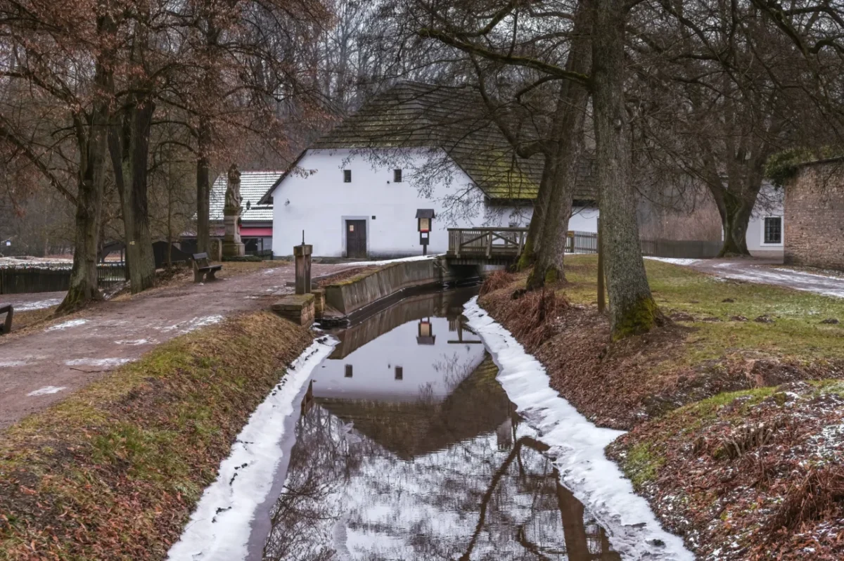 Bilá budova mlýna s cestou.