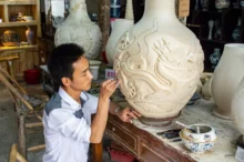 muž tvaruje keramickou vázu