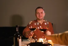 Muž si s někým připíjí.