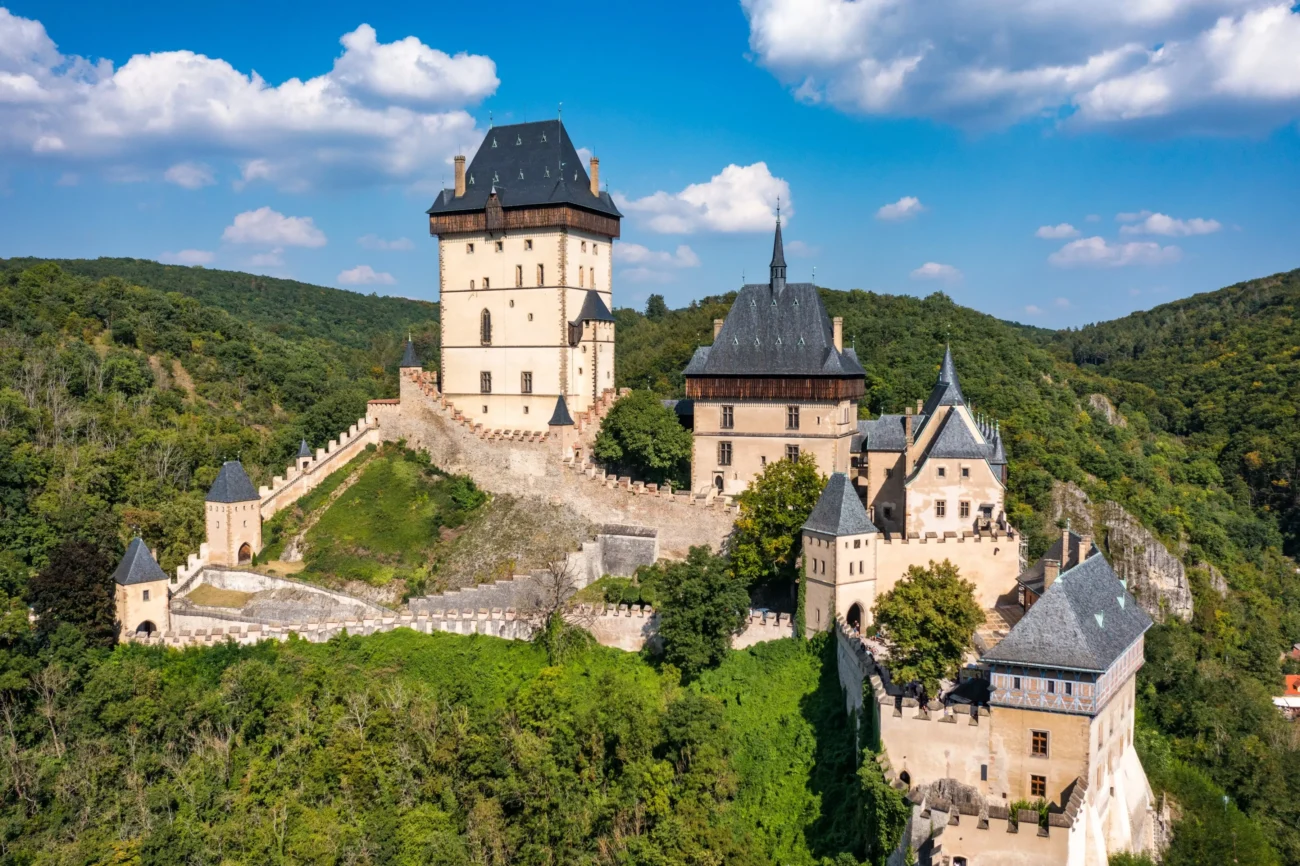 shutterstock_2233104201 1 | TVGURU.cz Bílý hrad se šedou střechou a hradbami.