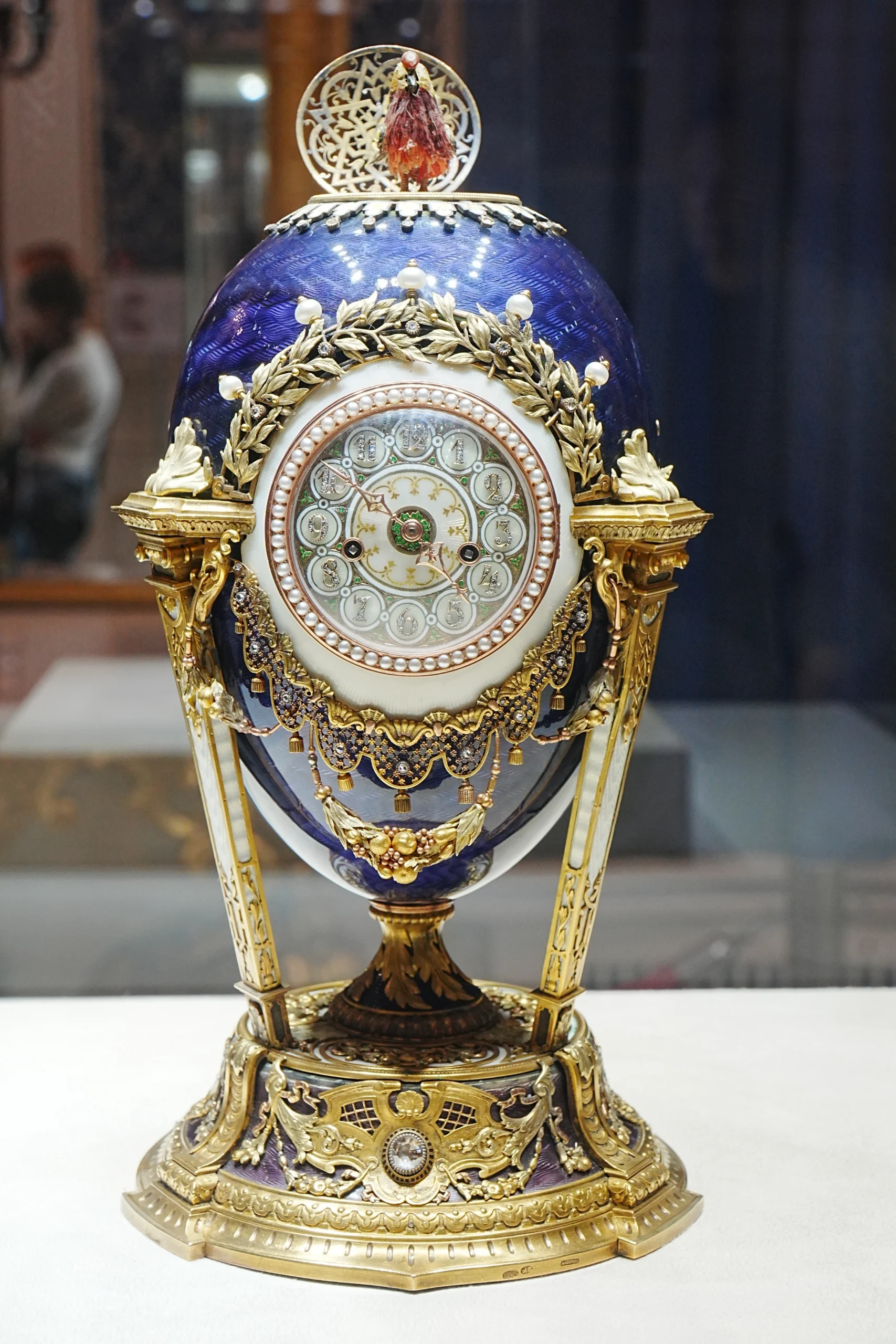 Modré Fabergého vejce s hodinami. Klenot - vejce na stojánku - zlaté, bohatě zdobené.