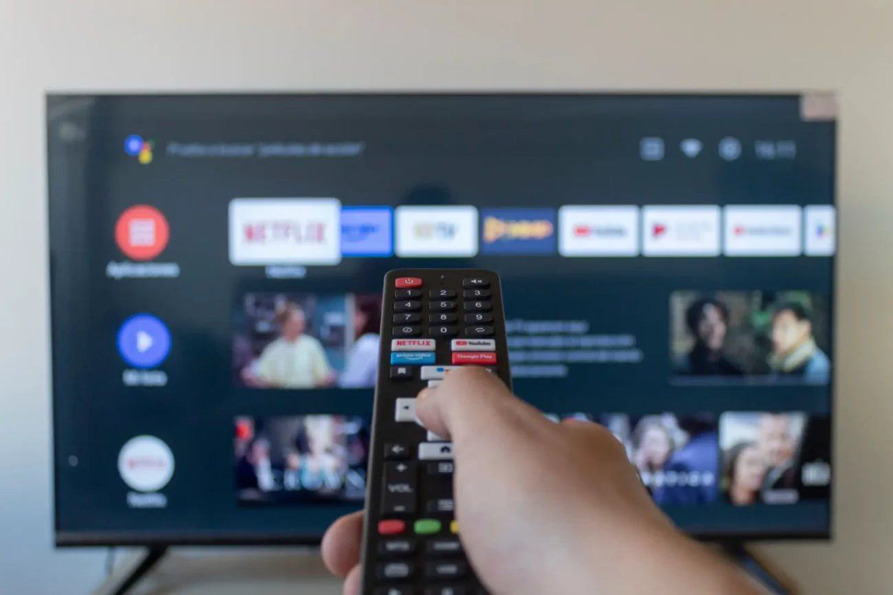 ruka s ovladačem míří na televizi na které jsou aplikace
