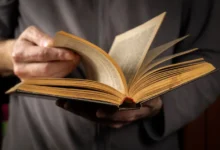 osoba listuje starou knihou