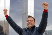 Muž zvedá ruce do vzduchu.