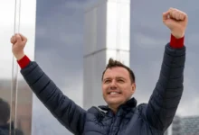 Muž zvedá ruce do vzduchu.