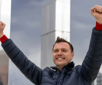 Muž zvedá ruce do vzduchu.
