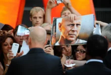 Bruce Willis obklopený fanoušky.