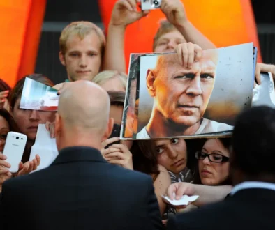 Bruce Willis obklopený fanoušky.