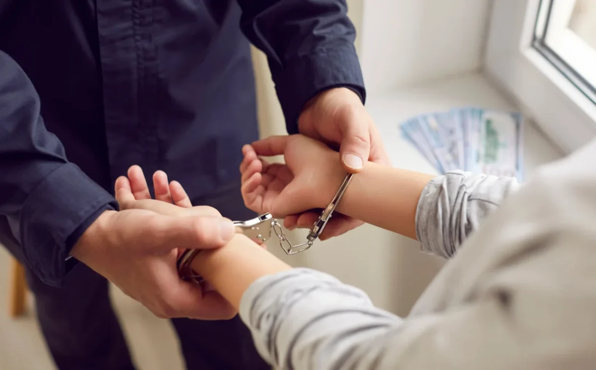 Policista muži dává pouta.