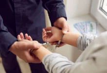 Policista muži dává pouta.