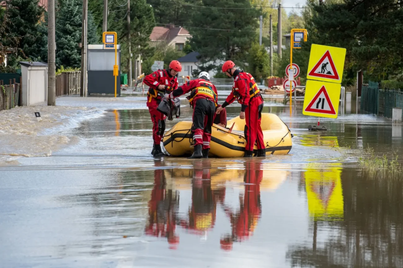 Shutterstock_2517382701 | TVGURU.cz zatopená silnice povodněmi a hasiči se člunem