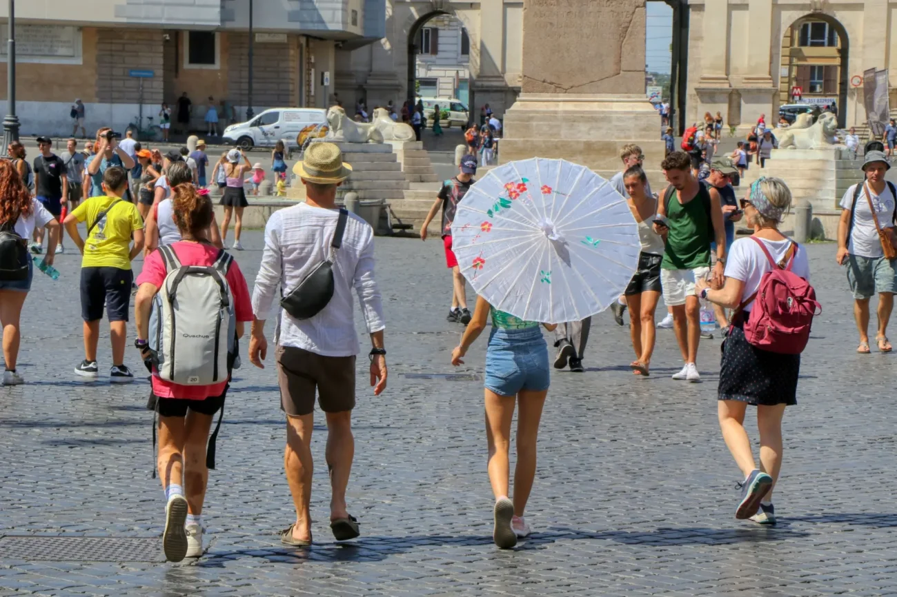 Shutterstock_2187538925 | TVGURU.cz turisti ve městě, jedna žena drží slunečník