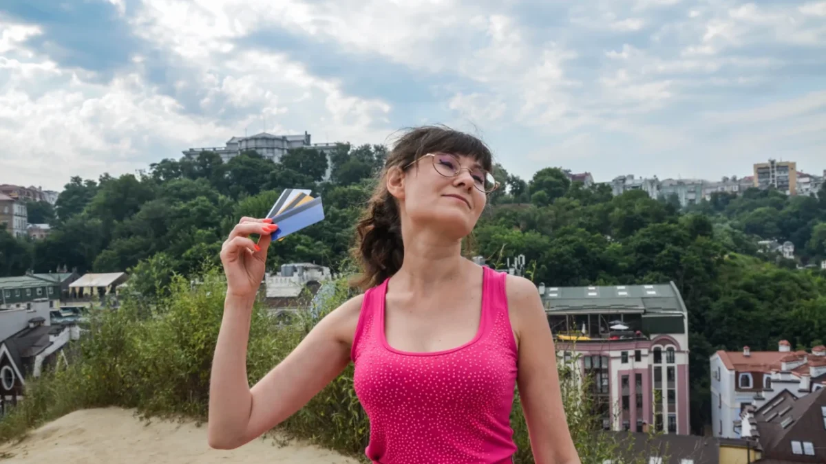 Žena se ovívá kartami.