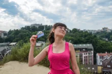 Žena se ovívá kartami.