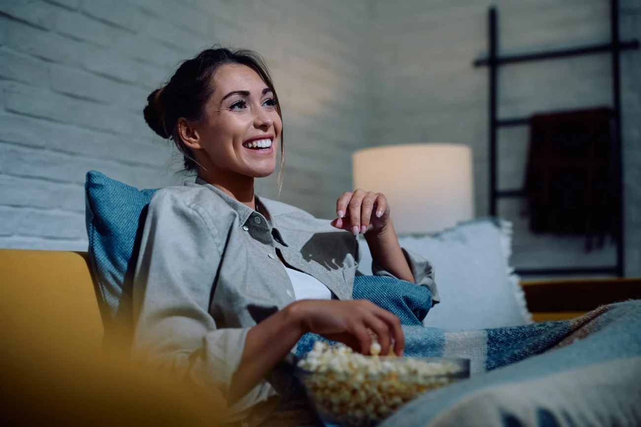 shutterstock_2530977367-min | TVGURU.cz žena jí popcorn před televizí