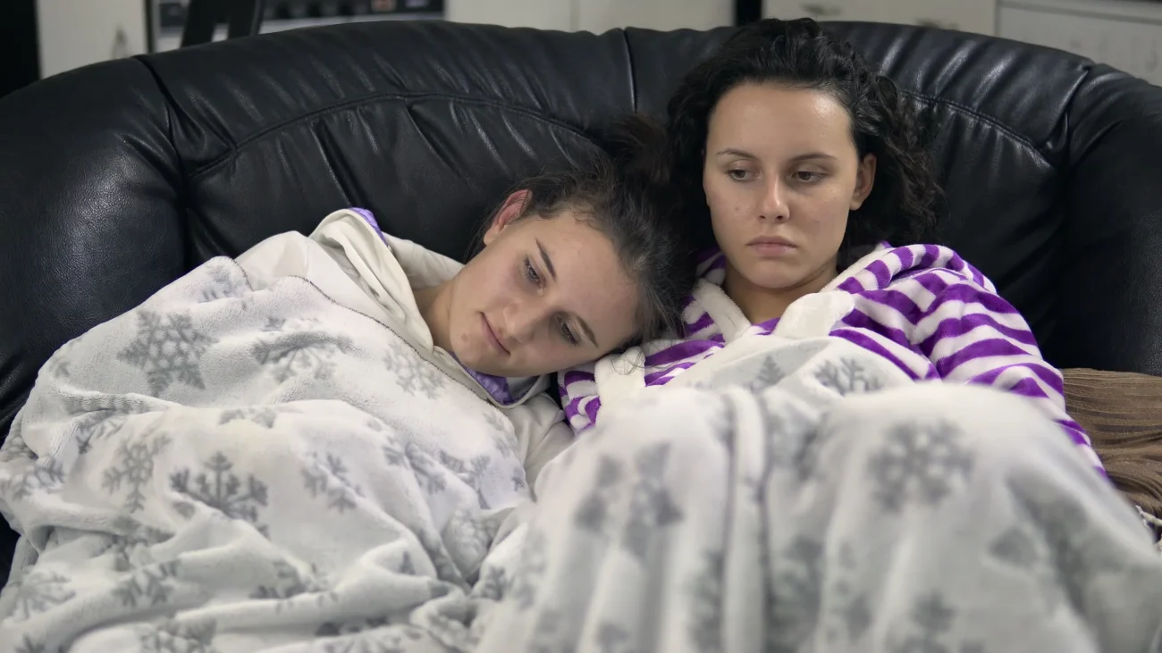 shutterstock_1018454482-2 | TVGURU.cz Dvě ženy leží na gauči zachumlané v dece.