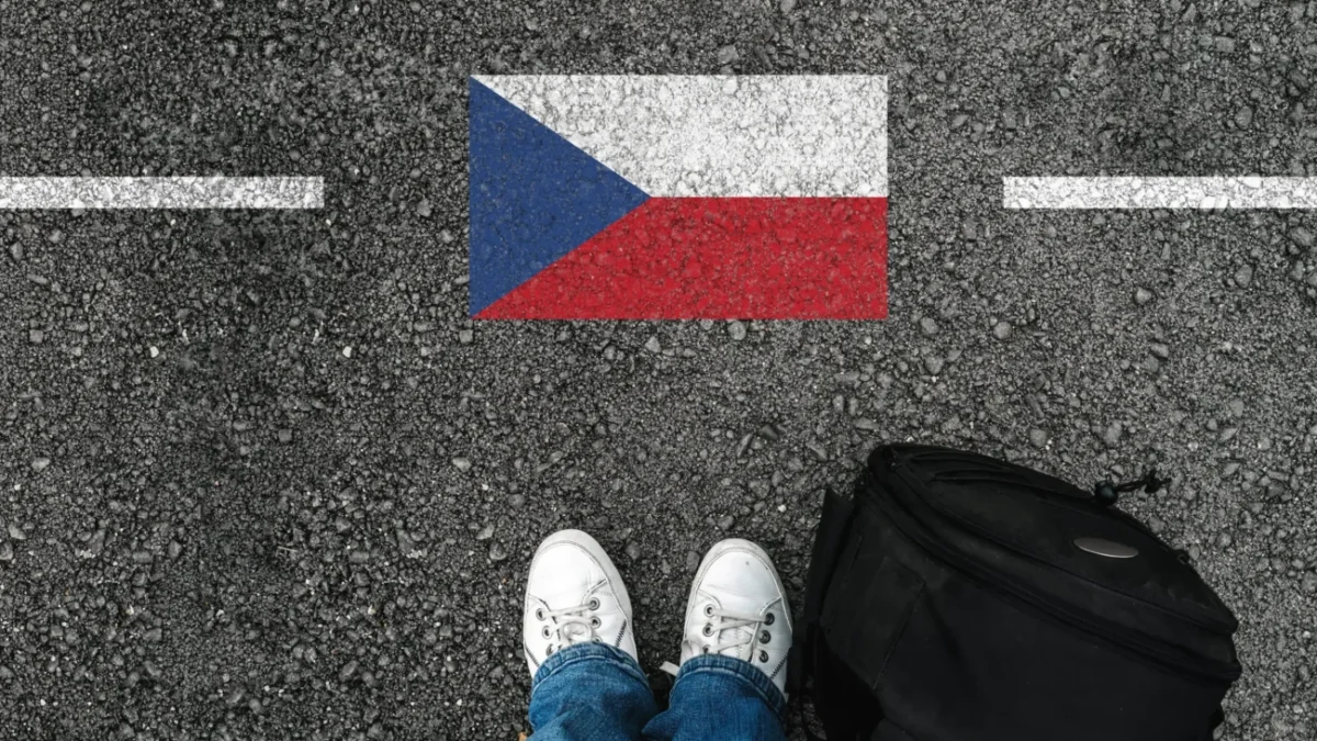 Muž stojí u české vlajky.