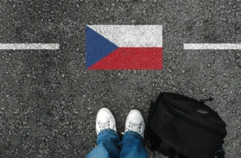 Muž stojí u české vlajky.