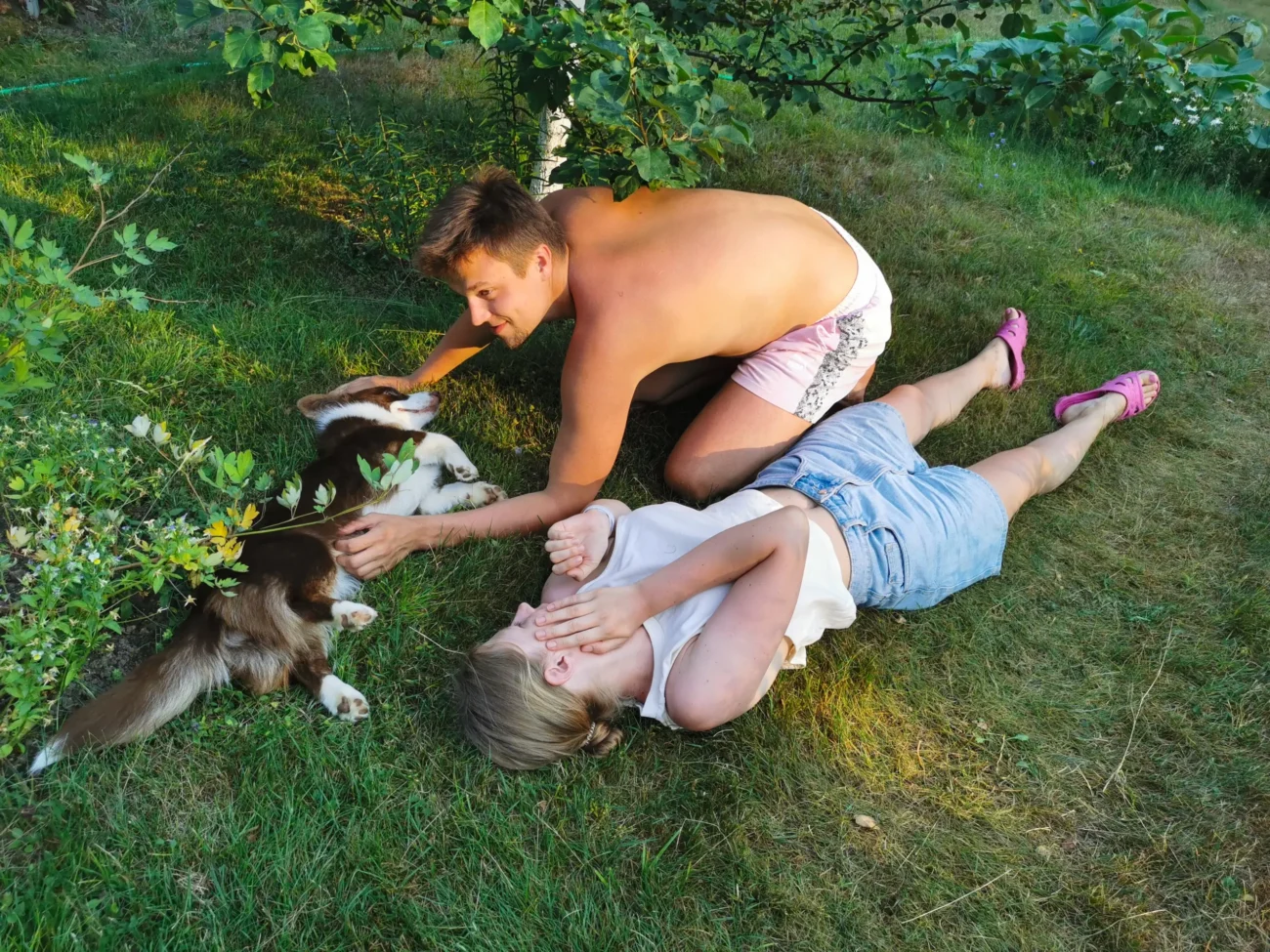 shutterstock_2008407914-2 | TVGURU.cz Muž, žena a pejsek se válí v trávě.
