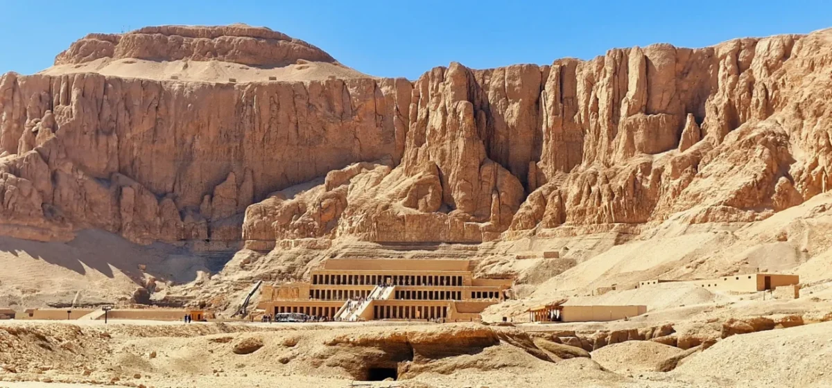 Poušť s horami a starým chrámem.