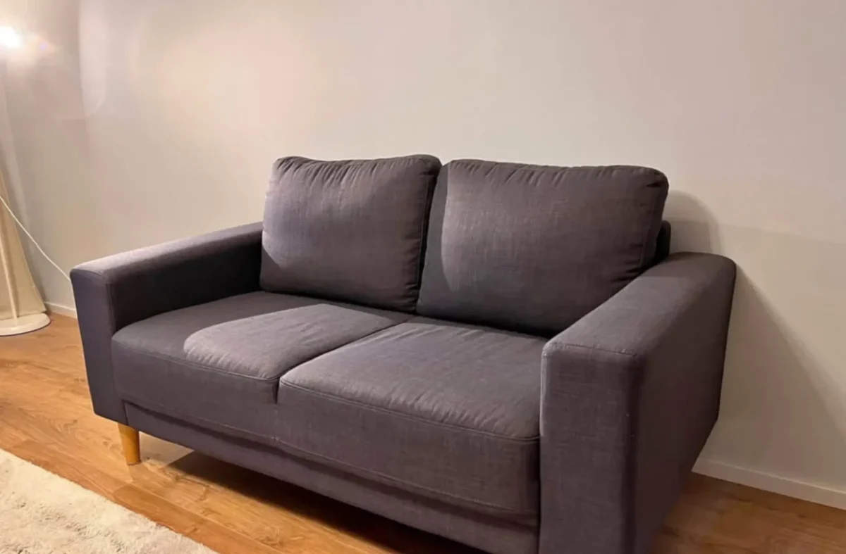 pohovka před bílou stěnou v obýváku