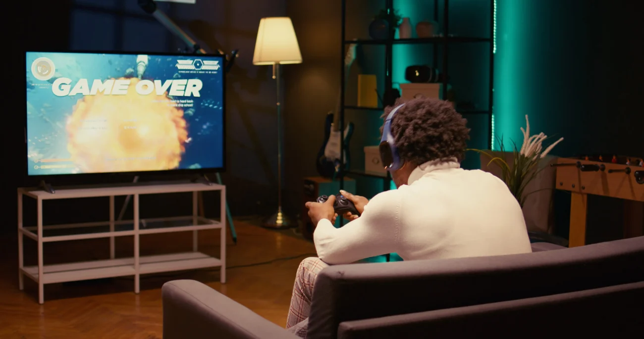 Smart televize lze používat k různým funkcím. Zdroj: Shutterstock | TVGURU.cz Muž hrající hru na chytré televizi.