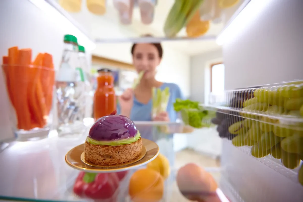 Žena se dívá do lednice.