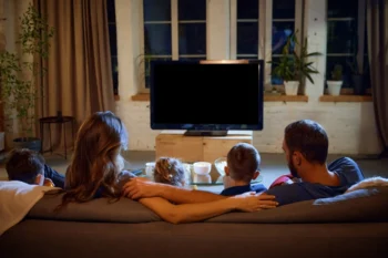 Rodina sedící na gauči u televize.
