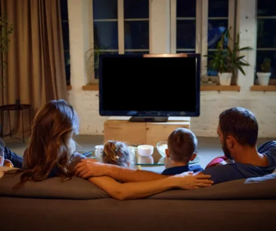 Rodina sedící na gauči u televize.