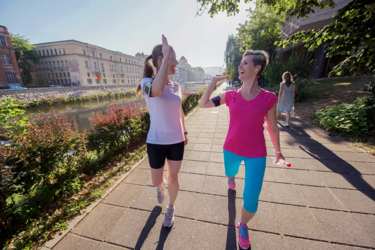 Ženy se prochází a plácají si rukou.