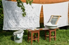 retro povlečení, které se suší na zahradě, vedle něj je valcha