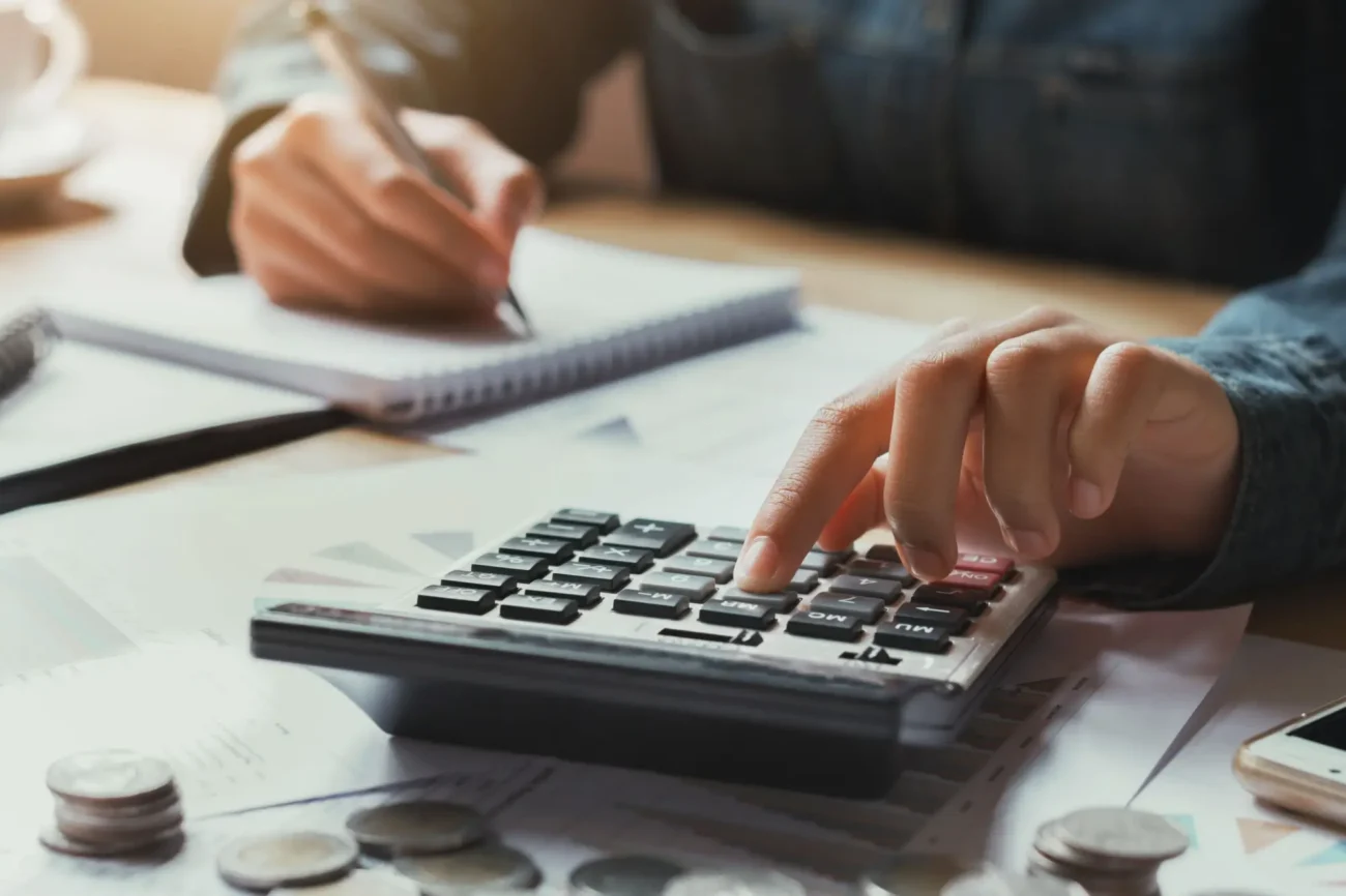 Shutterstock_771827434 | TVGURU.cz muž který si propočítává finance na kalkulačce, zapisuje si to