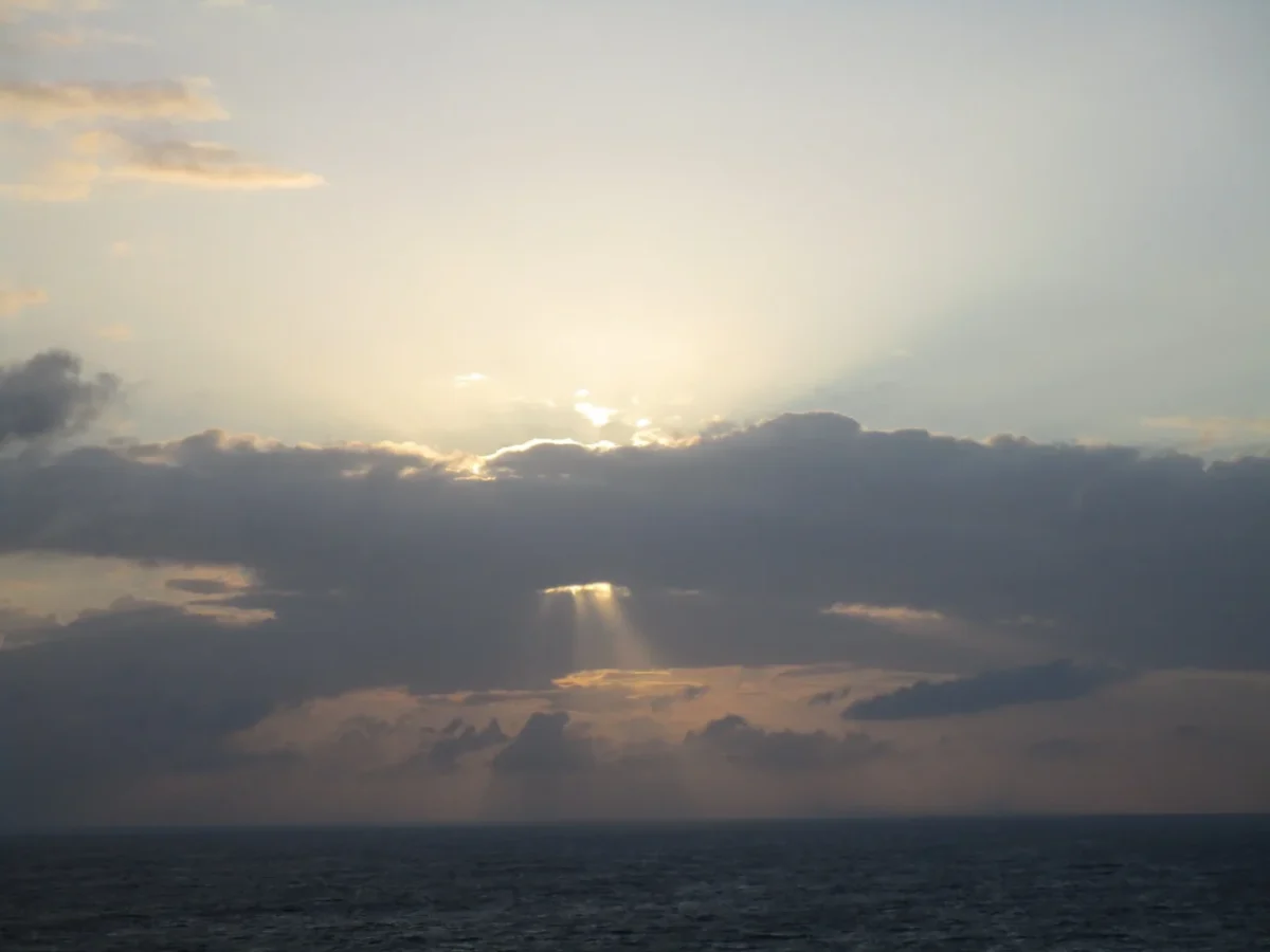 slunce vylézá zpoza mraků na nebi