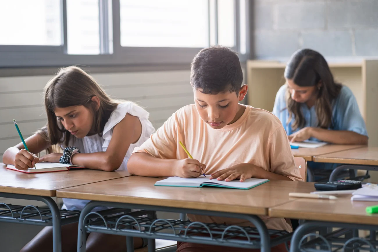 To, co jsme se naučili poměrně rychle můžeme také zapomenout. Zdroj: Shutterstock | TVGURU.cz Děti učící se v lavici.