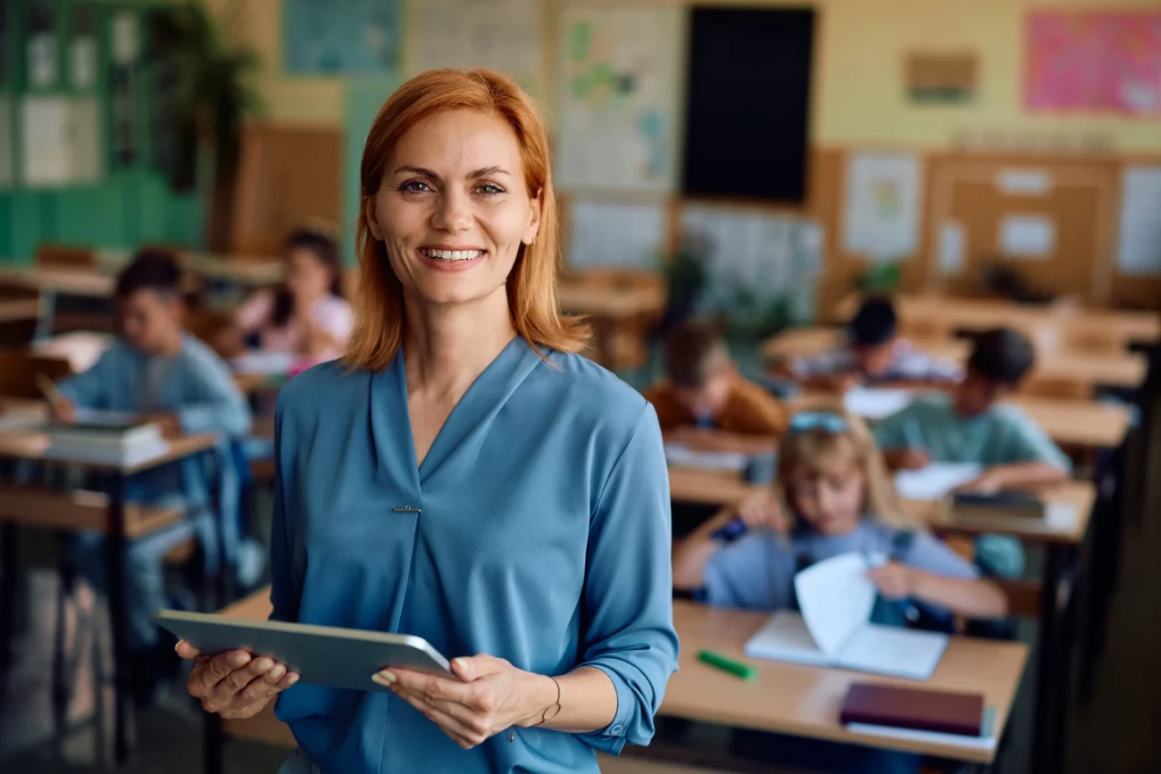 Existují způsoby, jak si lépe pamatovat informace. Zdroj: Shutterstock | TVGURU.cz Učitelka s žáky v pozadí.