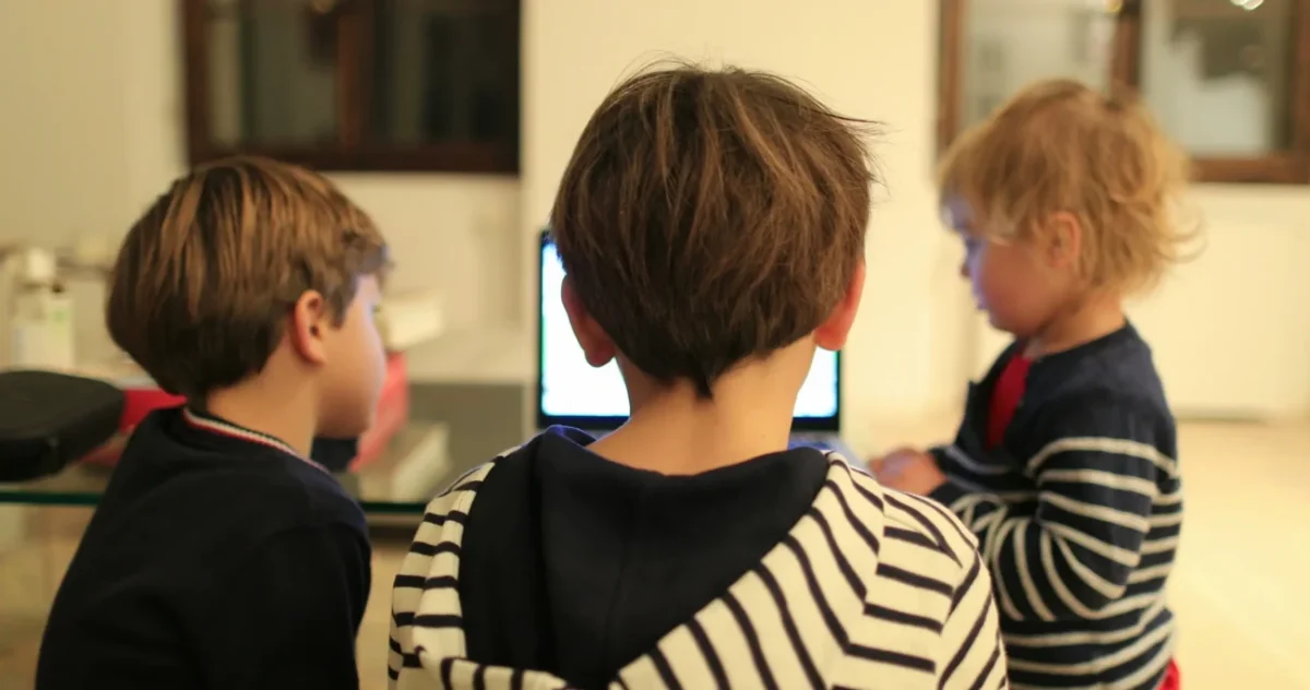 Chlapci stojí kolem notebooku.