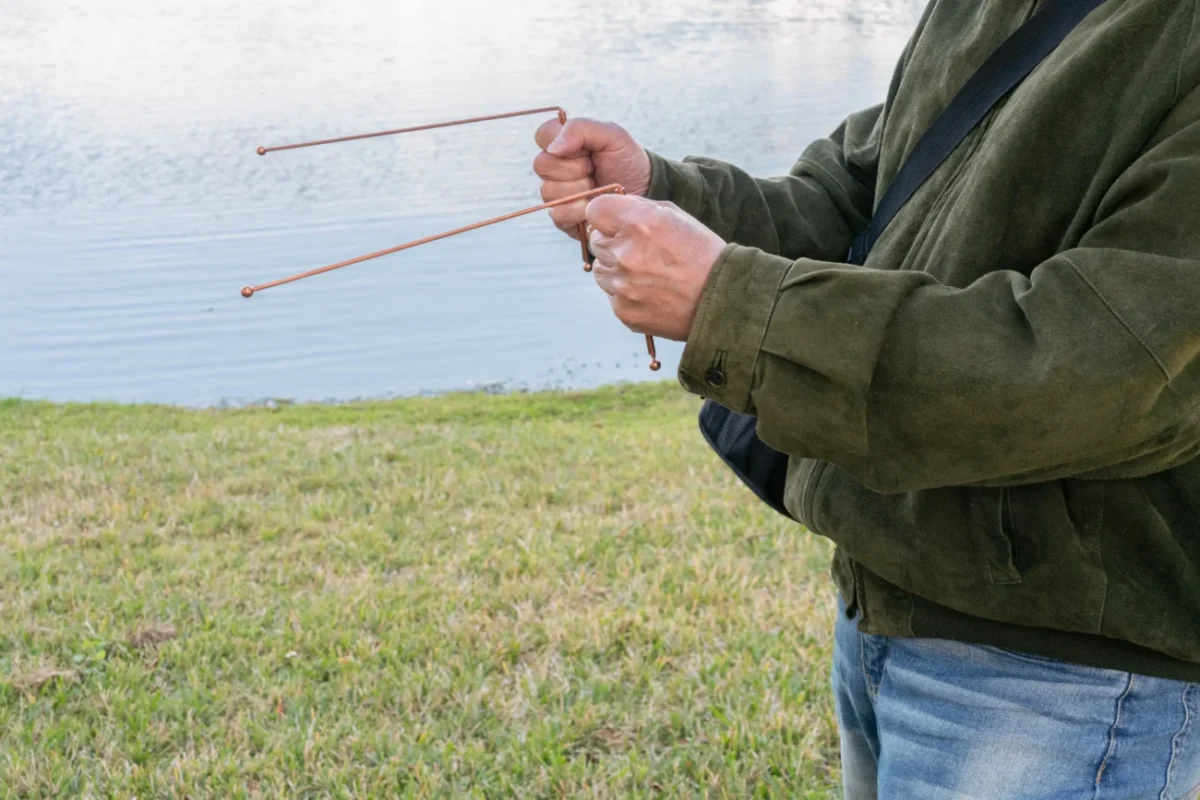muž drží dva zahnuté drátky