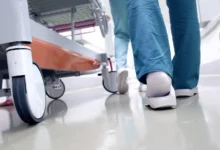 doktoři kráčí vedle pacienta, jdou vidět jen chodidla a kolečka vozíku
