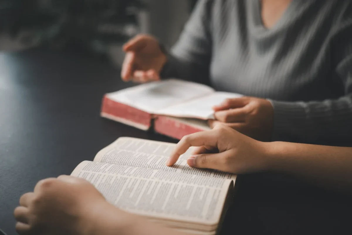 Lidé, kteří čtou ze starých knih.