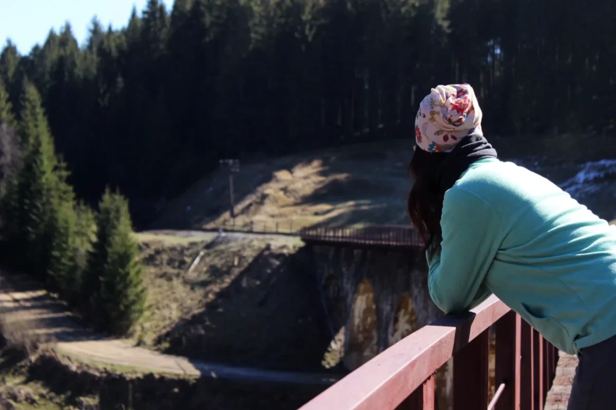 Žena se dívá z mostu do propasti.