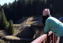 Žena se dívá z mostu do propasti.