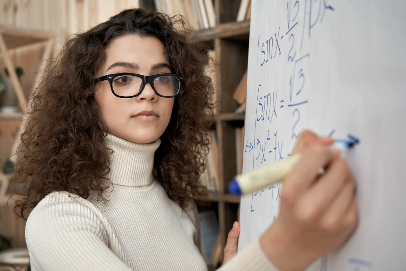 Při počítání mnoho z nás dělá chyby z nepozornosti. Zdroj: Shutterstock | TVGURU.cz Dívka počítající na tabuli.