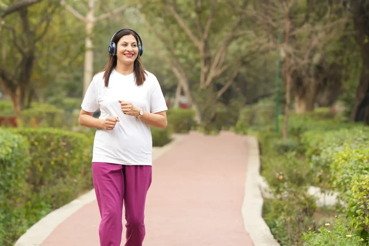 Žena se sluchátky v přírodě.