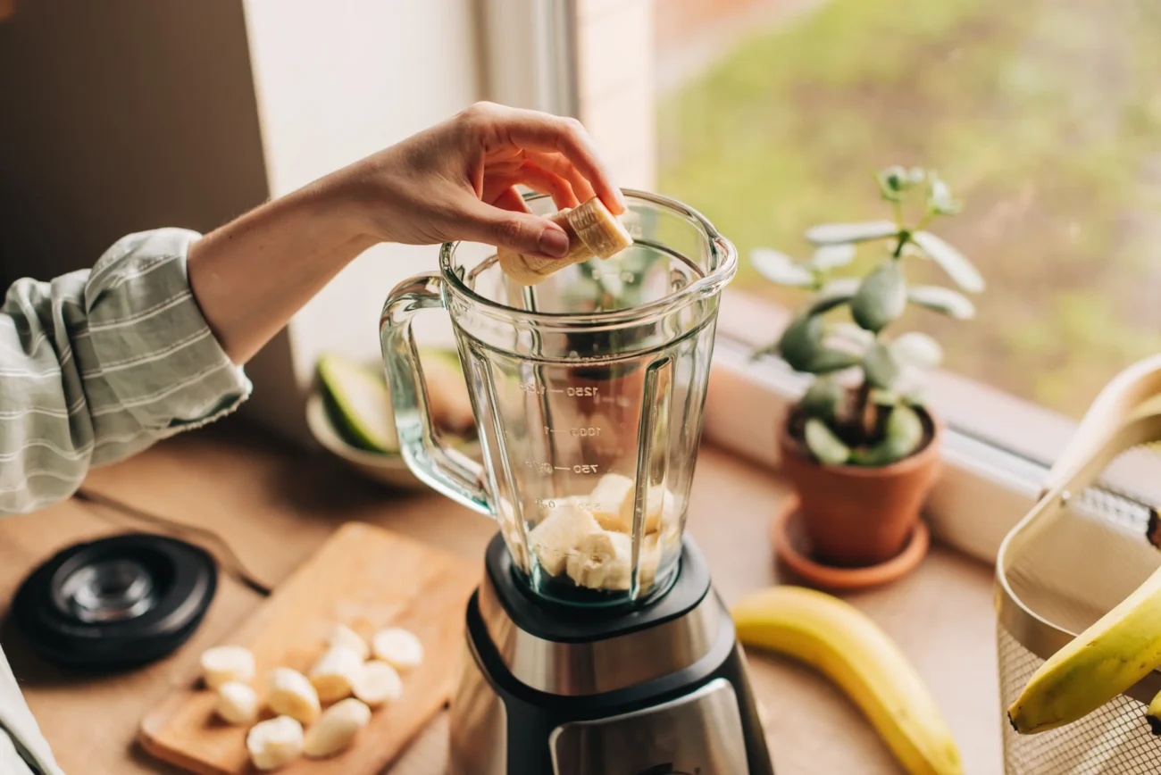 Z ovoce i zeleniny lze připravit chutné smoothie. Zdroj: Shutterstock | TVGURU.cz Ruka připravující smoothie v mixéru.