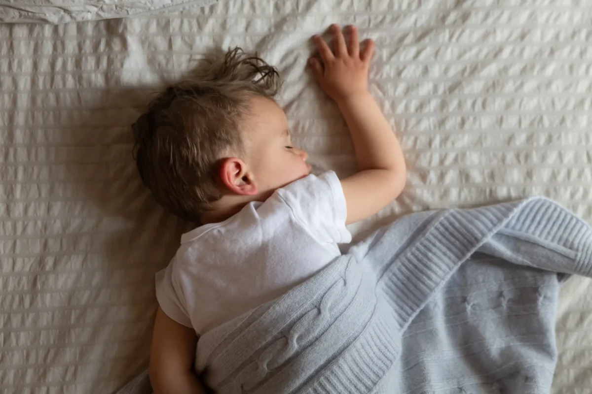 Chlapeček v posteli spí.
