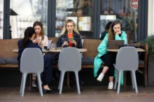 Ženy sedí venku v kavárně.