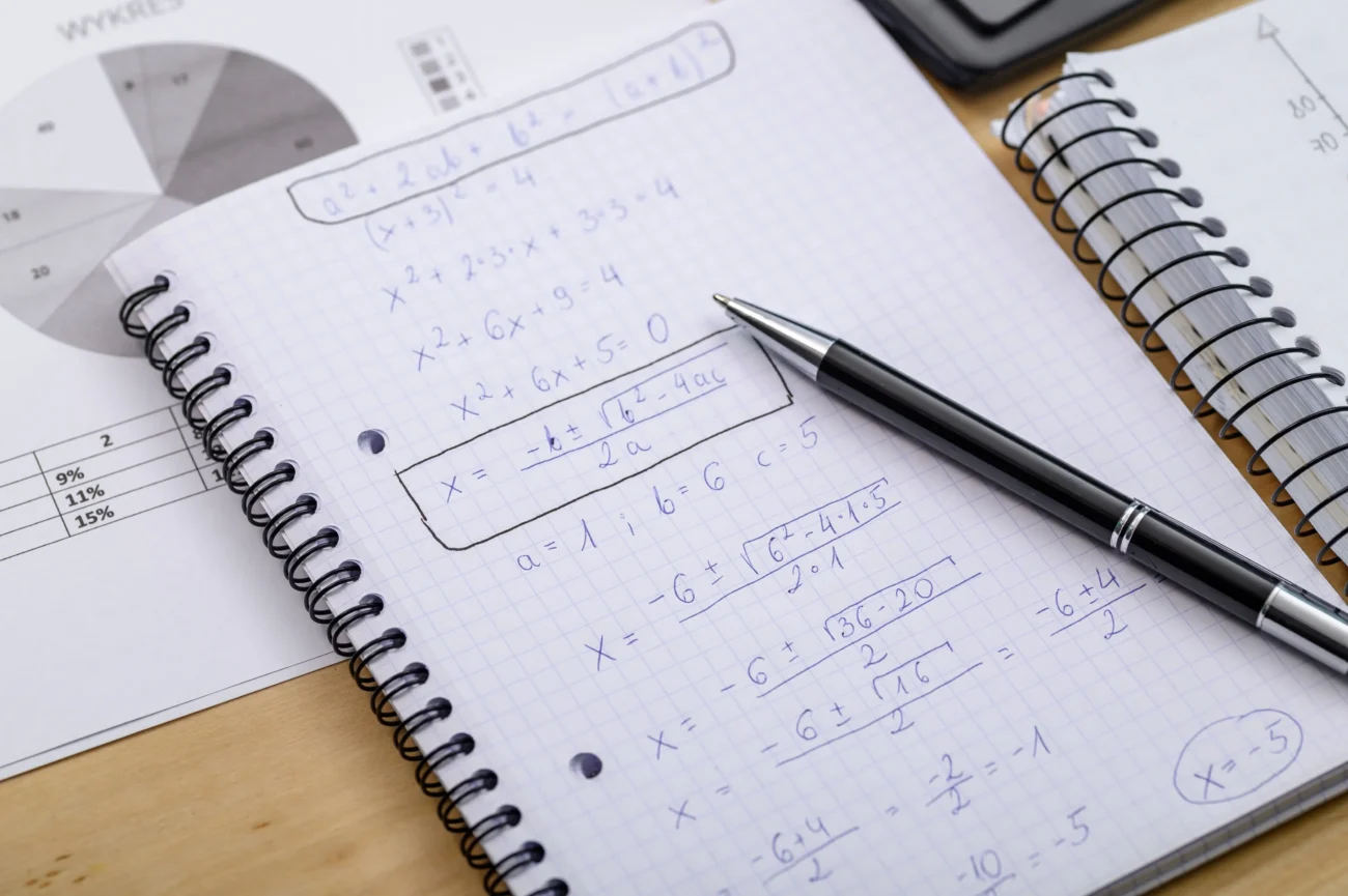 V sešitě je napsaný matematický příklad.