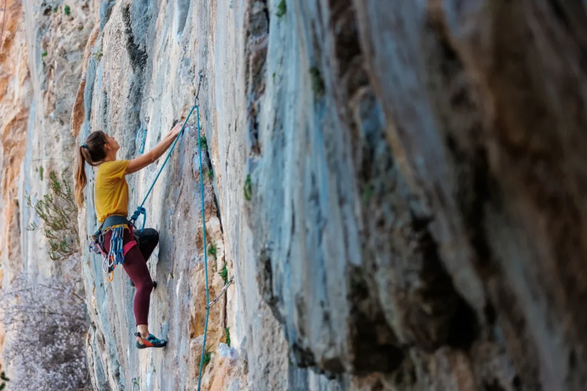 Žena leze po skále.