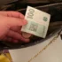 české koruny stokoruna drží ruka a dává do kabelky